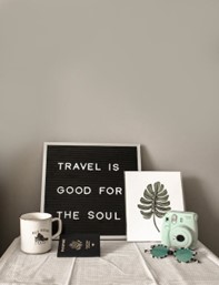 a passport, mug, camera, and frame on a table